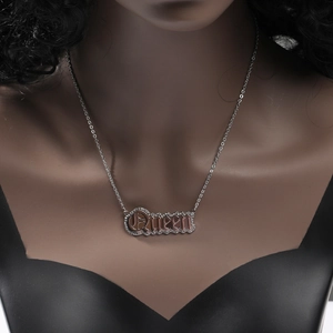 Close-up of double-layered Queen letter pendant with rose gold finish and zircon inlay