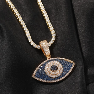 Vue macro du pendentif Evil Eye hip-hop serti de cristaux sur une chaîne tennis or