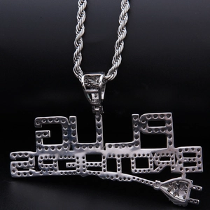 Primer plano de collar hip hop plateado con letras PLUG ESTATE y detalle de enchufe