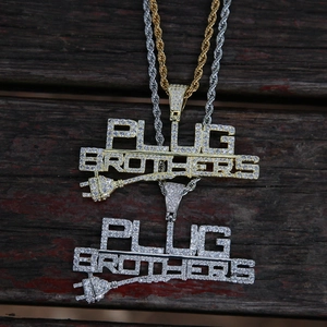 Vista detallada de colgantes de hip hop Plug Brothers en oro y plata con piedras de circón