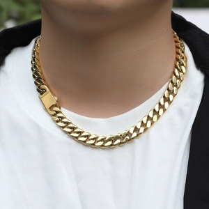 Detail of 12mm golden cuban link necklace on male model wearing a black jacket