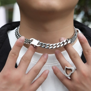 Close-up of 12mm stainless steel Cuban link chain and heart-shaped rhinestone ring on model