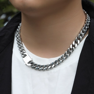 Detail of 12mm stainless steel Cuban link necklace with large spring buckle on male model