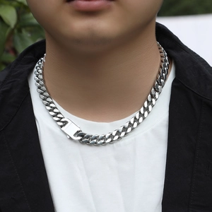 Close-up of 12mm silver stainless steel Cuban link necklace with mechanical buckle on model