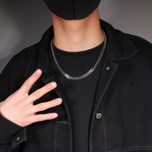 Close-up of a 12mm silver stainless steel cuban chain necklace worn on a black shirt