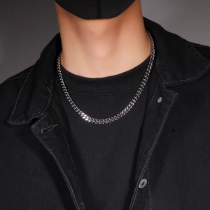 Close-up detail of a polished 12mm stainless steel curb chain necklace on male model
