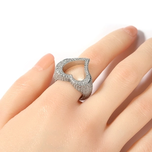 Gros plan d'une bague en forme de cœur évidé avec pavé de zircons portée par le mannequin