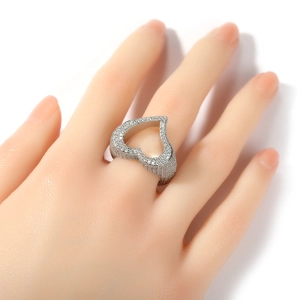 Gros plan d'une bague coeur ajourée en argent avec zircons sur un mannequin