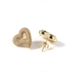 Detailed macro view of heart-shaped gold studs with sparkling cubic zirconia inlay
