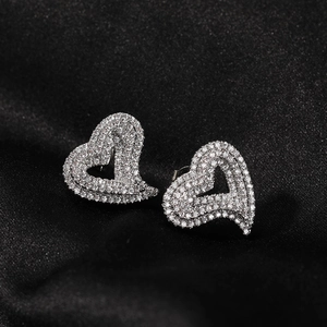 Sparkling silver heart stud earrings with cubic zirconia on black silk background
