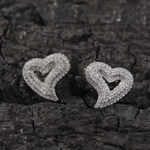 Detailed close-up of heart-shaped silver earrings with sparkling pavé cubic zirconia