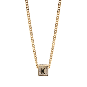 Détail macro du pendentif carré doré avec lettre K et pierres de zircone serties