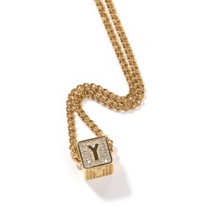 Détail macro de la chaîne cubaine dorée et pendentif carré lettre Y avec pierres zircon