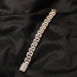 Detail eines goldenen Panzerarmbands mit Zirkonia-Besatz auf schwarzem Seidenstoff