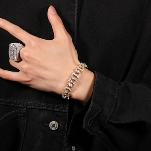 Detail eines Hip-Hop-Gold-Cuban-Armbands mit Zirkonia-Pavé und silbernem Siegelring