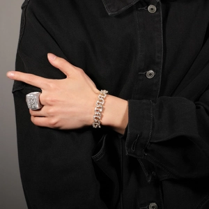 Nahaufnahme von Hip-Hop-Silberring mit Zirkonia und Goldkette am Modell