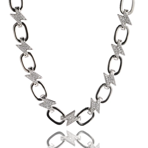 Dettaglio ravvicinato di una collana a fulmine con zirconi intarsiati e maglie in metallo