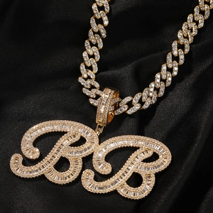 Gros plan sur le pendentif lettre BB serti de diamants sur une chaîne cubaine dorée