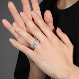 Nahaufnahme eines luxuriösen breiten Rings mit rechteckigen Zirkoniasteinen an der Hand