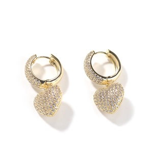 Macro shot of gold-plated hip hop heart earrings with white micro-pave zircons