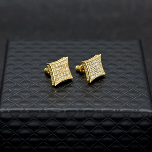Makroaufnahme goldener quadratischer Ohrstecker mit Zirkonia auf einer Schmuckschatulle