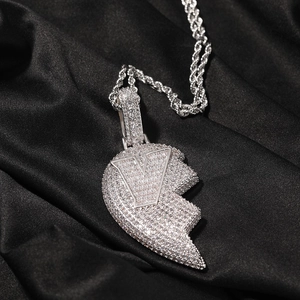 Macro-detail van zilveren hip-hop gedraaide touwketting en iced-out hart V hanger