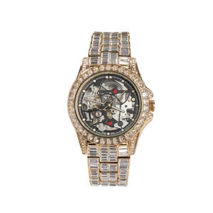 Macro detail of iced out gold mechanical watch showing skeleton dial and square diamonds