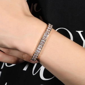 Vue détaillée d'un bracelet tennis doré serti de zircons rectangulaires sur un modèle