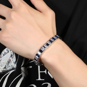 Gros plan d'un bracelet tennis hip hop avec alternance de zircons bleus et blancs