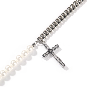 Détail macro du mélange de chaîne cubaine et collier de perles avec pendentif croix