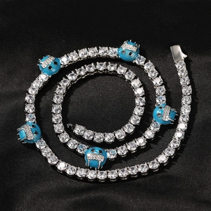 Detalle de collar hip hop con circonitas y colgantes de esmalte azul sobre seda negra