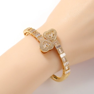 Gros plan d'un bracelet doré en forme de cœur avec zircons porté au poignet