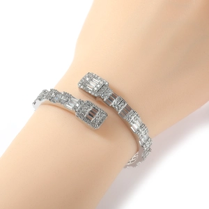 Detailansicht eines silbernen Hip-Hop-Armreifs mit Diamanten am Handgelenk des Models