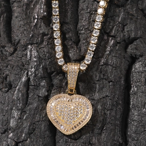 Nahaufnahme der Hiphop-Herz-Halskette in Gold mit Zirkonia-Besatz auf schwarzem Holz