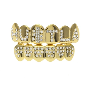 Close-up of hip hop gold teeth grills with HUSTLA letter design and white rhinestones