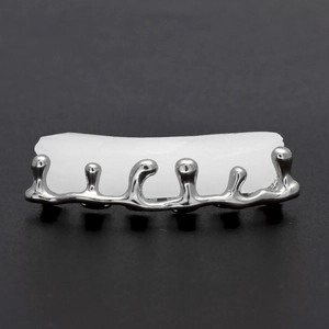 Vue macro de grillz argentés 6 dents style métal liquide avec barre de silicone