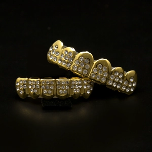Detail macro view of hip hop gold plated teeth grills set encrusted with clear zircons