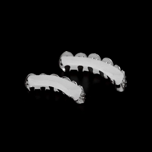 Macro detail of silver hip hop grillz with white silicone fixing bars on black background