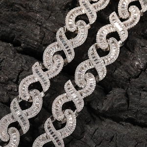 Close-up of hip hop silver necklace with pave-set crystals on dark charcoal background