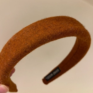 Solid color wool felt headband for women in brown orange featuring a handmade label