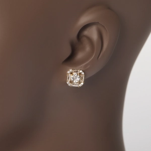 Detail of gold square halo earrings with baguette zircons on a dark skin model