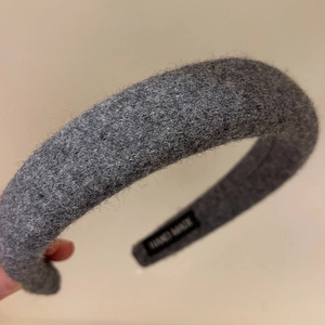 Detail of gray wool felt headband showing soft texture and handmade label tag
