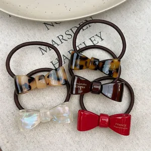5-piece set of acetate bow hair ties in tortoiseshell, red, white, and brown colors