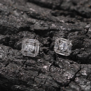 Macro shot of silver square stud earrings with central round diamond and baguette zircon