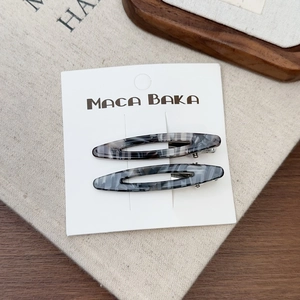 Lot de deux barrettes en acétate ovales creuses motif marbre gris sur carte de support