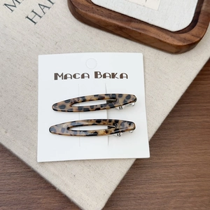 Gros plan de barrettes à imprimé léopard en acétate avec motif feuille évidée
