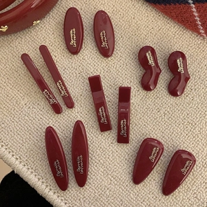 French retro burgundy bow hair clips set with golden lettering on knit fabric
