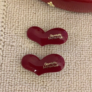 Vintage French wine red heart hair clips with gold label on beige fabric