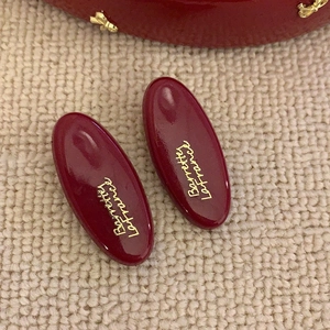 Detailed close-up of wine red oval barrettes with gold Barrette Lafrance script