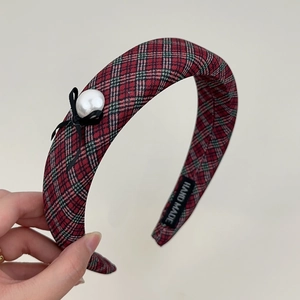 Macro detail of the hand-made fabric label inside the red and green plaid headband